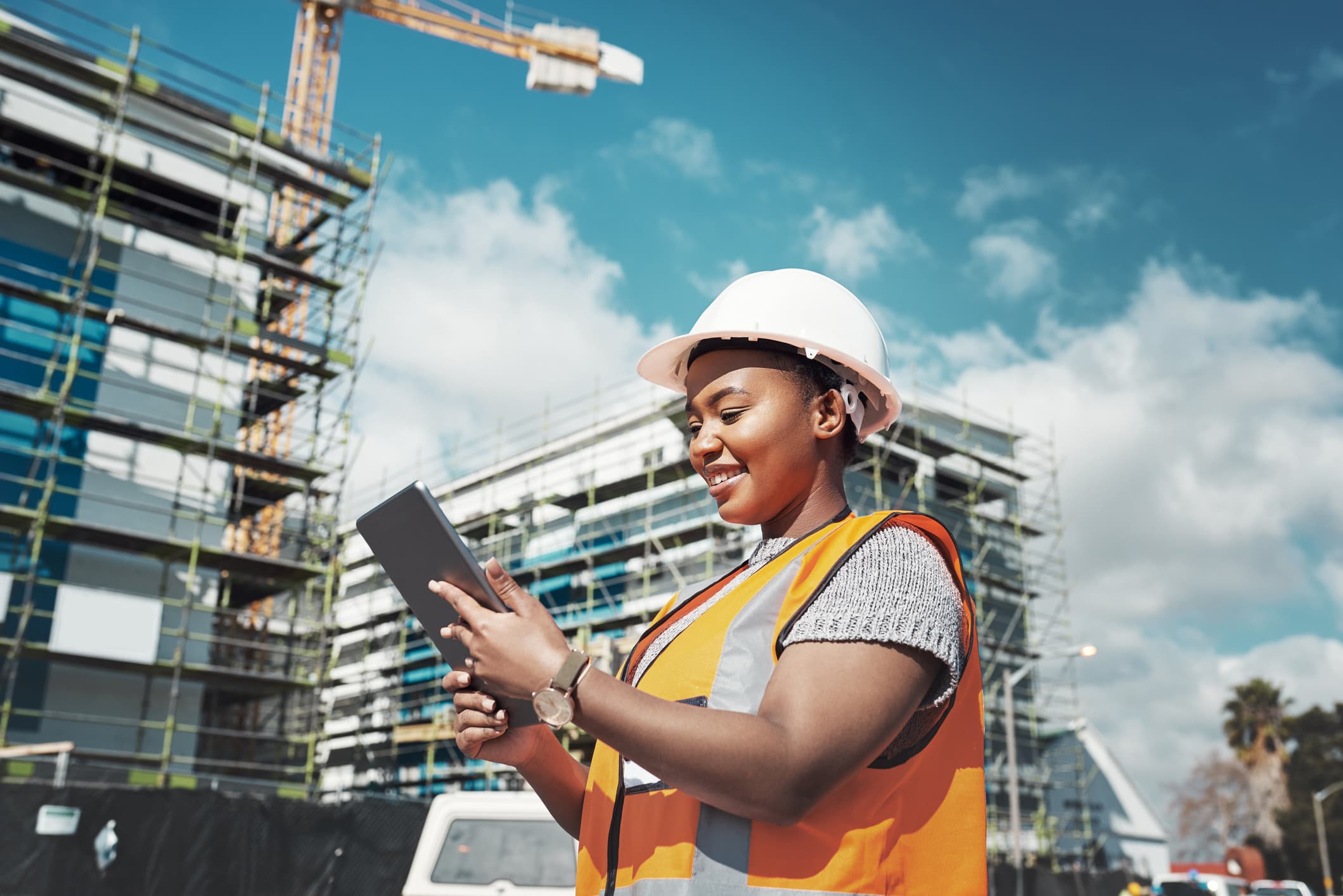A construction worker consults her iPad on site